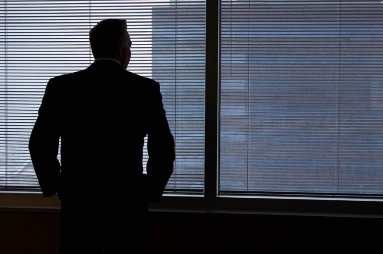 Business man alone looking out office window
