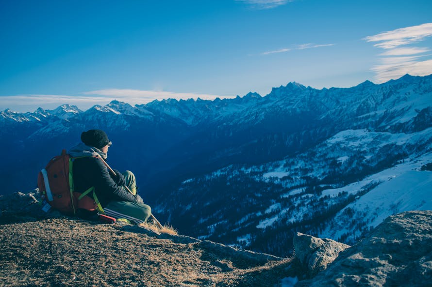 Senior leader sitting at the top of a mountain looking out across a landscape